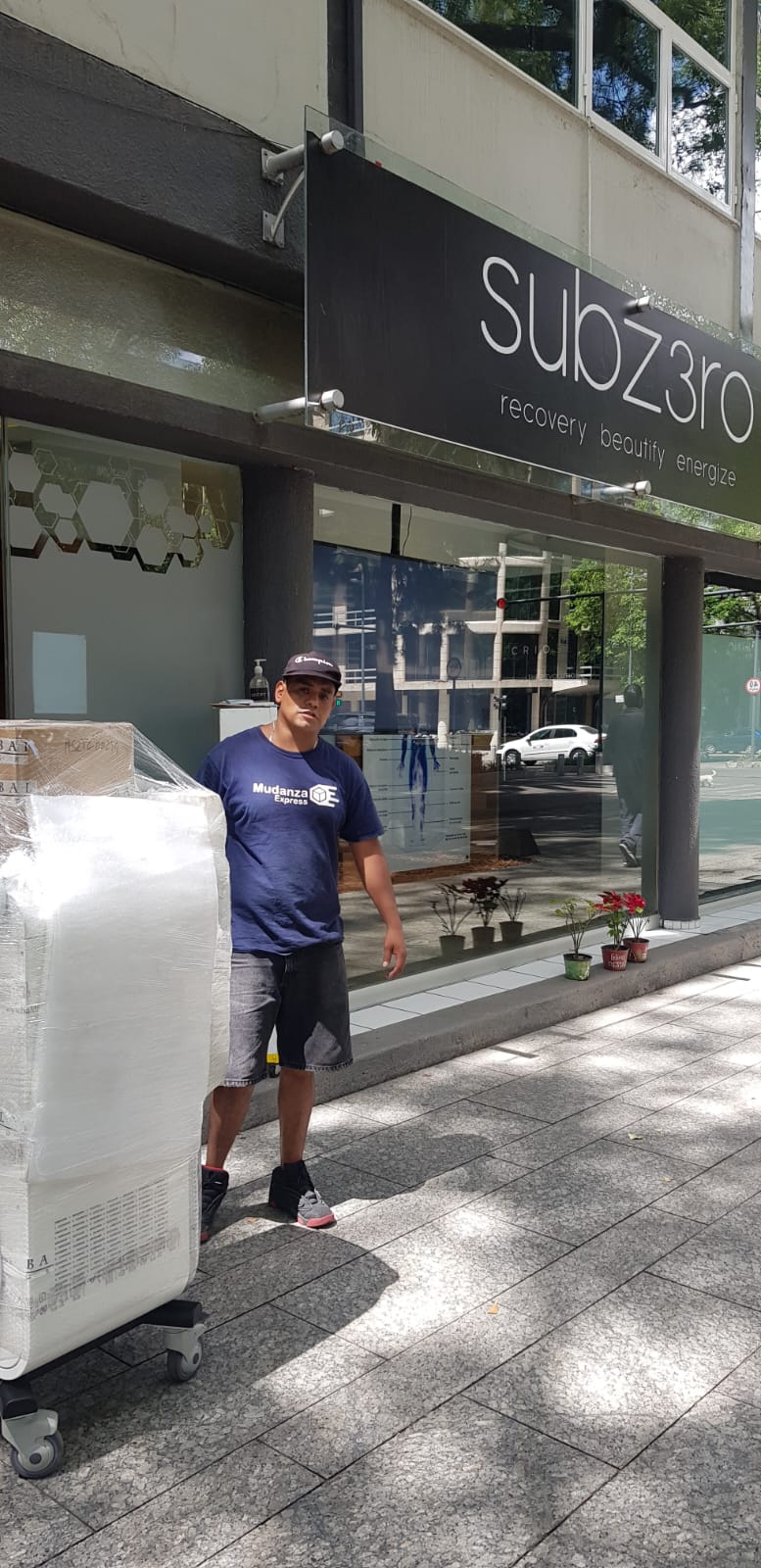 Colaborador de Mudanza Express con uniforme de la empresa trasladando mercancía embalada